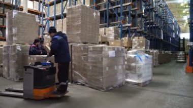 Sennoy, Rusya Federasyonu 14 Şubat 2018: Yükleyicilerin modern bir depoda karton kutularla dolu paletleri yükleme çalışmaları