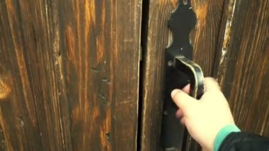 Adam kapıyı açıyor, içeri giriyor ve metal merdivenlerden bodruma iniyor.