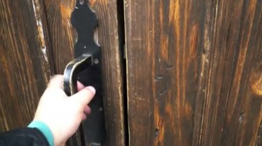 Adam kapıyı açıyor, içeri giriyor ve metal merdivenlerden bodruma iniyor.