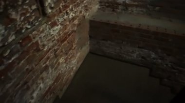 Metal bir merdivende tuğla duvarlarla bodruma inin.