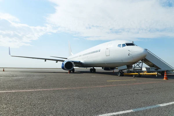 Avión en el estacionamiento con pasarela de pasajeros equipada en el — Foto de Stock