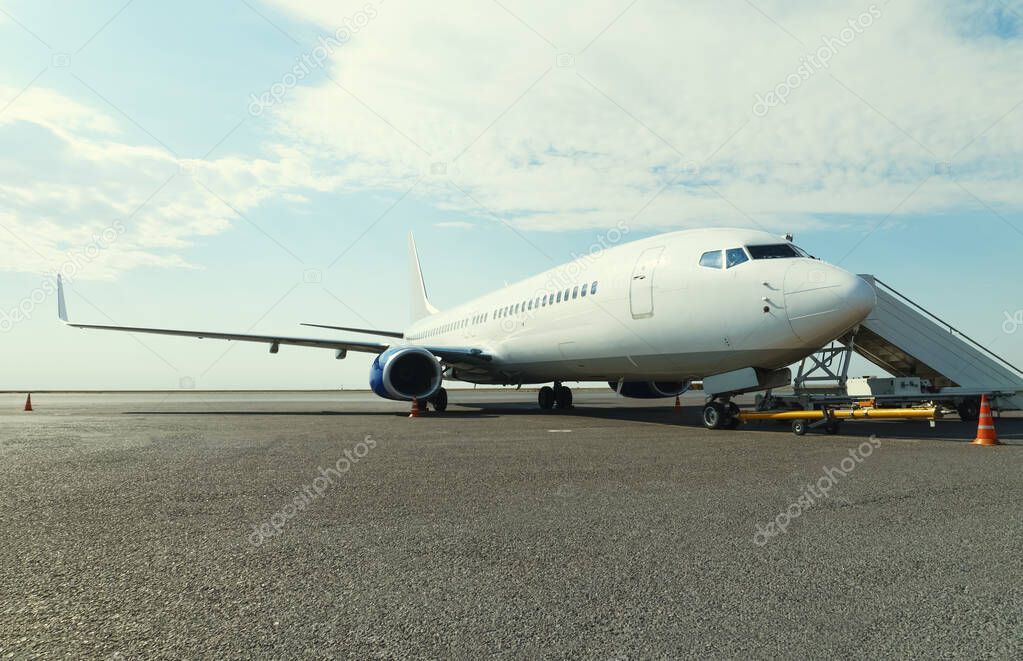 Airplane in the parking lot with fitted passenger gangway at the