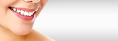 Gri bir arka plan boşaltmak ile gülümseyen güzel kadın