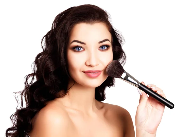 Mooi meisje met een make-up borstel, geïsoleerd op witte achtergrond — Stockfoto