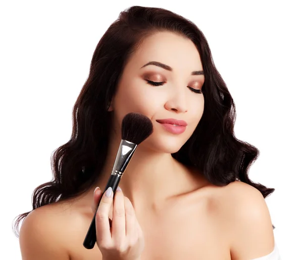 Mooi meisje met een make-up borstel, geïsoleerd op witte achtergrond — Stockfoto