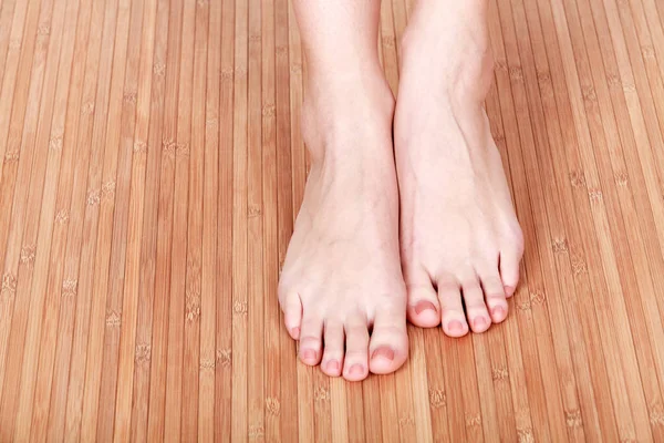 Female feet on wooden floor — Stock Photo, Image