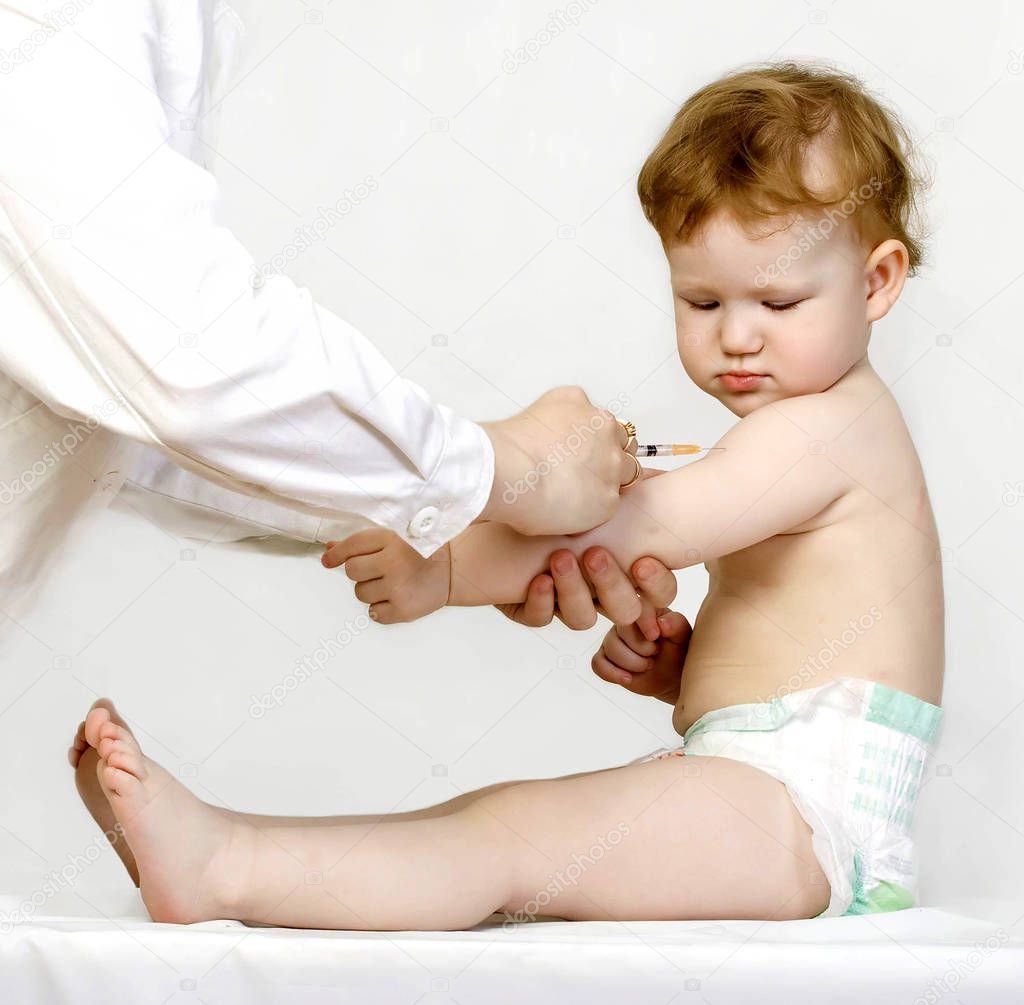 Doctor giving a child a vaccine injection in arm