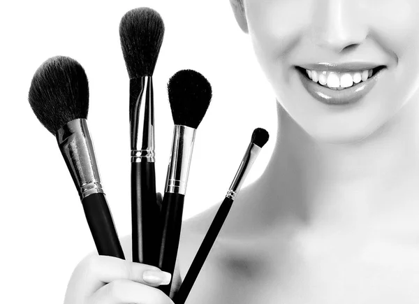 Kvinna med kosmetikborstar, vit bakgrund, copyspace — Stockfoto