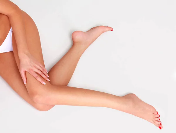 Pernas de mulher em um chão cinza claro — Fotografia de Stock