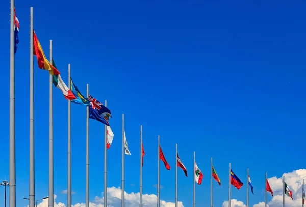 Internationale vlaggen tegen een blauwe hemel — Stockfoto