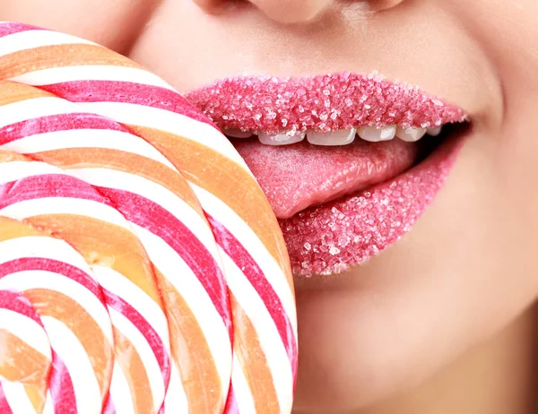 Крупный план женских губ, покрытых сахаром и большим леденцом — стоковое фото