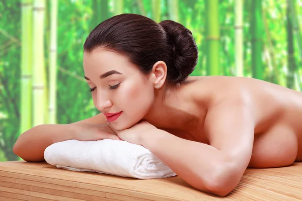 Jovem mulher bonita relaxando no salão de spa na floresta de bambu — Fotografia de Stock