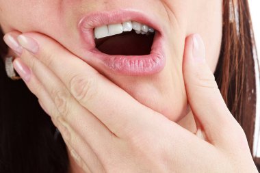 Closeup of woman in strong toothache pain with hands over face.  clipart