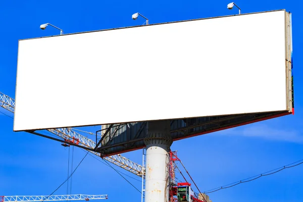 Große weiße Plakatwand mit blauem Himmel dahinter. — Stockfoto