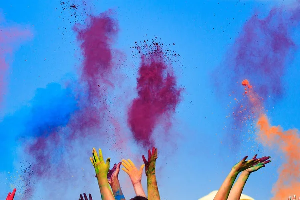 Na cor Holi Festival, mãos no ar, céu azul atrás — Fotografia de Stock