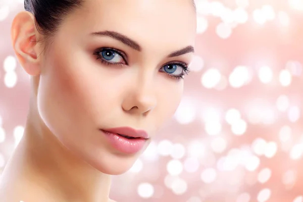 Closeup shot of beautiful female face against an abstract background with blurred lights — Stock Photo, Image