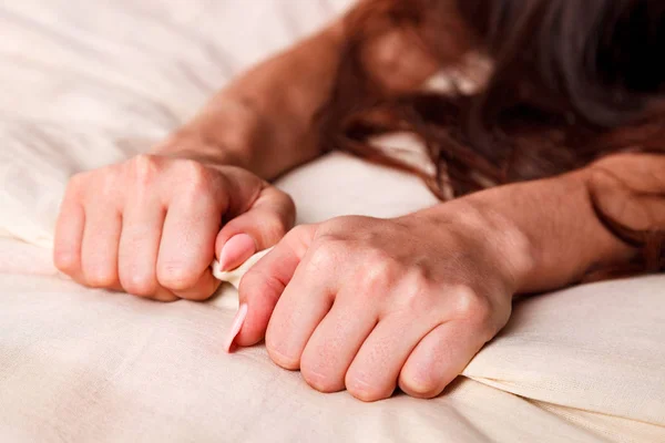 Las manos de la mujer tirando de sábanas blancas en éxtasis, orgasmo — Foto de Stock