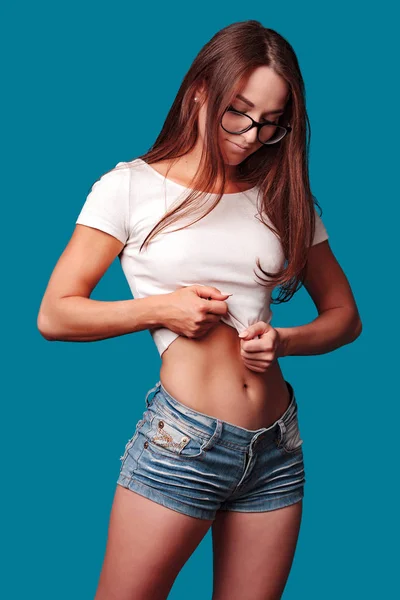 Sexy vrouw dragen van bril poseren tegen blauwe achtergrond — Stockfoto