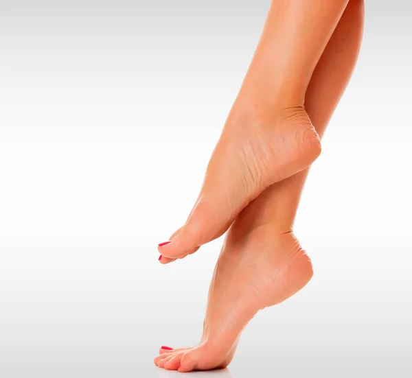 Kadın ayakları ile boşaltmak gri bir arka plan — Stok fotoğraf
