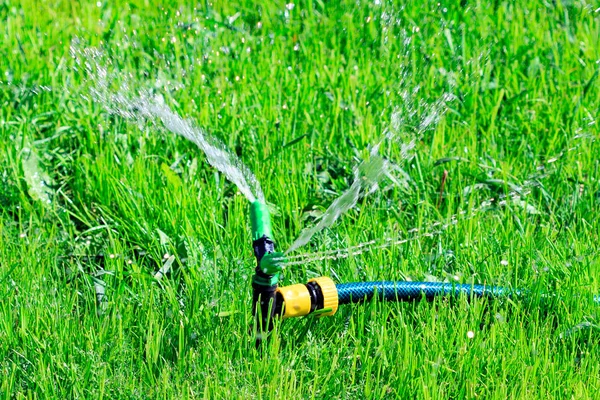 黄色草坪洒水器在绿草场上喷水的镜头 灌溉系统 — 图库照片