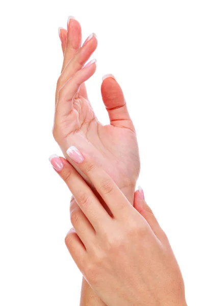 Primer plano de las manos de la mujer con manicura francesa y piel limpia y suave sobre un fondo blanco, aislado —  Fotos de Stock
