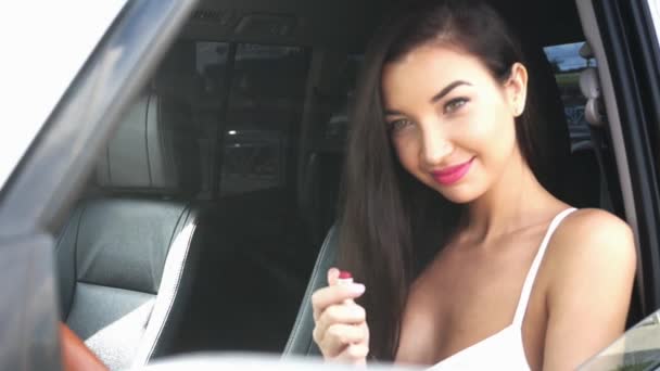 Mujer joven sentada en un coche haciendo maquillaje — Vídeos de Stock