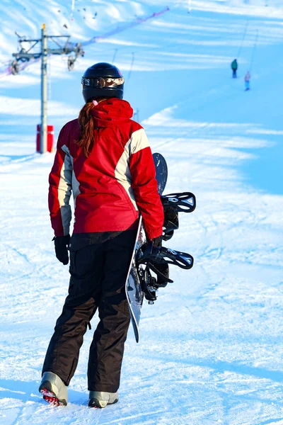 Femme snowboarder sur les pistes de neige par une journée ensoleillée d'hiver — Photo