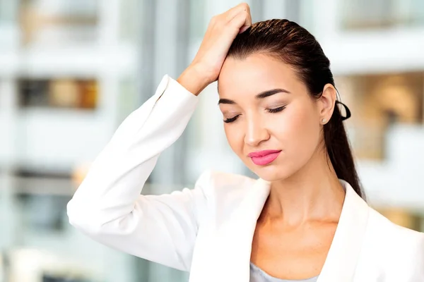 Vrouw met een hoofdpijn in een kantoor. Vrouw vergeten iets. — Stockfoto