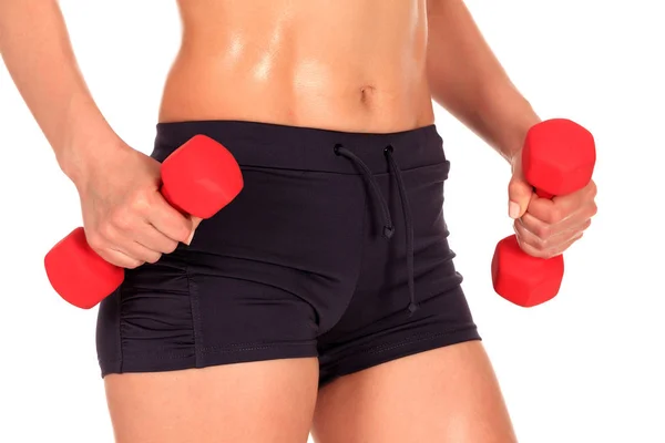 Beautiful body of a young fit slim woman lifting dumbbells isolated on white background — Stock Photo, Image