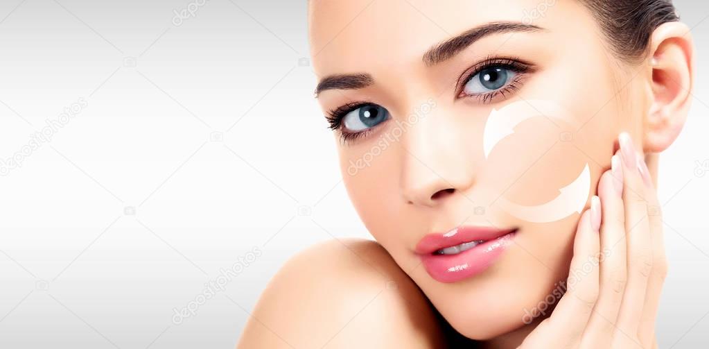 Young woman's face, antiaging concept, grey background.