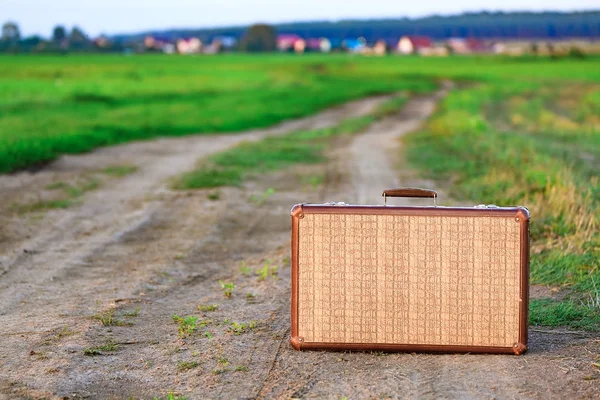 Retro stijl oude koffer op een weg van het platteland — Stockfoto