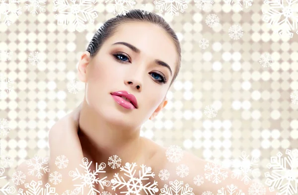 Pretty woman against an abstract background with circles and snowflakes. Winter skin treatment concept — Stock Photo, Image