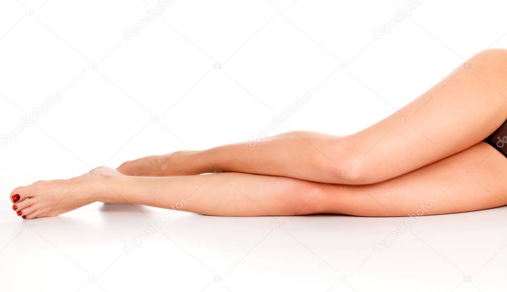Closeup shot of long beautiful female legs. Woman with slim legs posing on white background