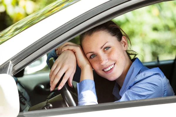 Glad tjej driver leende till dig från bilen — Stockfoto