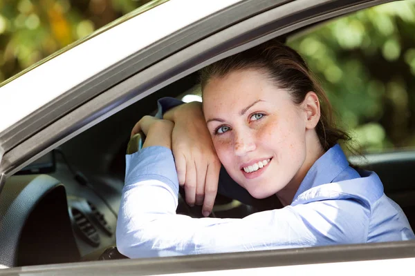 Sterownik szczęśliwy dziewczyna uśmiecha się do Ciebie z samochodu — Zdjęcie stockowe