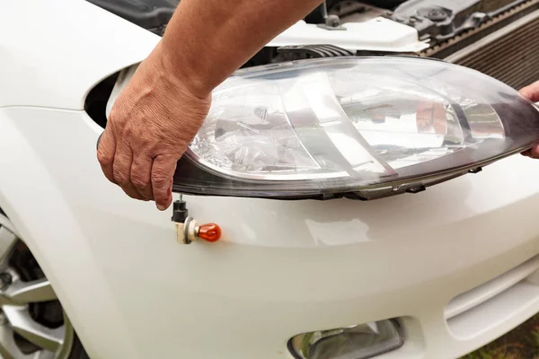 Head lights repair. Mechanic holding a new spare part — Stock Photo, Image