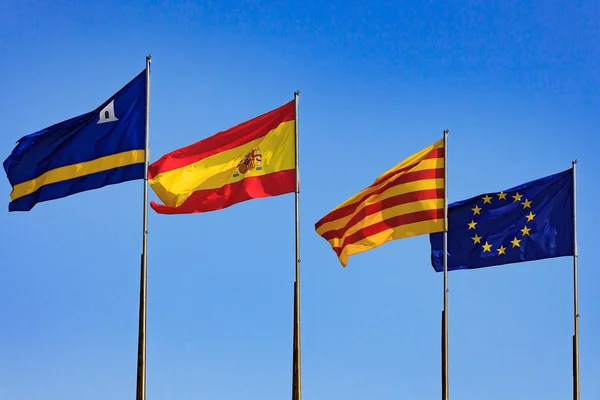 Flaggen von Spanien, Salou, Katalonien, Europäische Union gegen blauen Himmel — Stockfoto