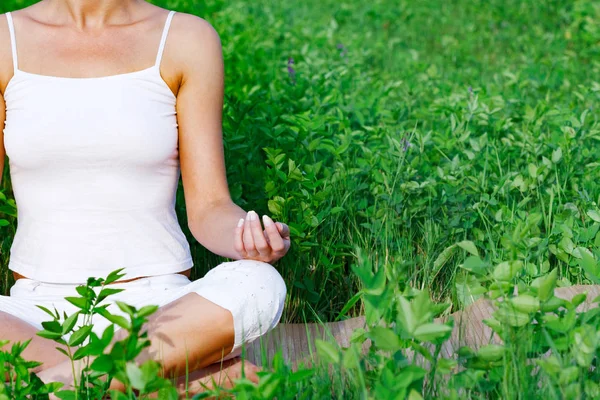 Jóga žena sedí v zelené trávě — Stock fotografie