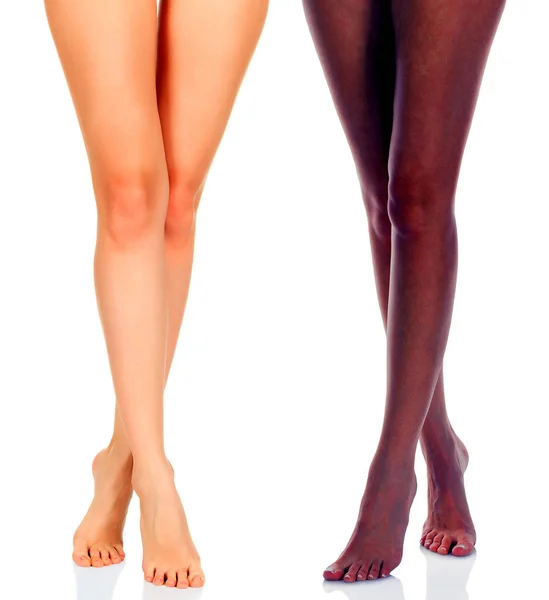 Largas piernas de mujer de chicas negras y caucásicas aisladas sobre fondo blanco —  Fotos de Stock