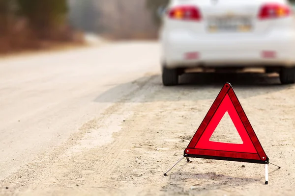 Sinal triângulo vermelho e automóvel na estrada, profundidade de visão rasa — Fotografia de Stock