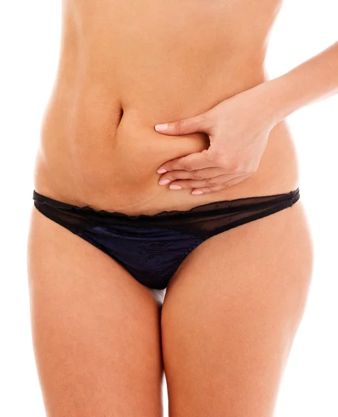Gros plan d'une femme en surpoids pincant sa graisse abdominale excessive, isolée sur fond blanc — Photo