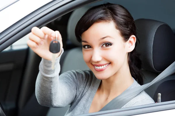 Щасливий водій жінки, що показує ключ автомобіля — стокове фото