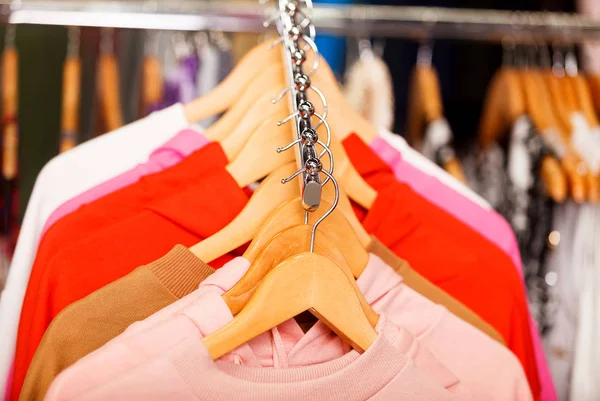 Strzał zbliżenie ubrania powiesić na półce w nowoczesny Sklep odzieżowy — Zdjęcie stockowe