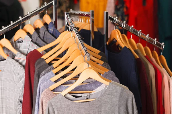 Gros plan de vêtements accrochés sur une étagère dans un magasin de mode moderne — Photo