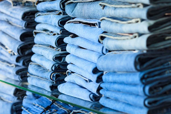 Крупный план стопки сложенных джинсов в магазине моды — стоковое фото