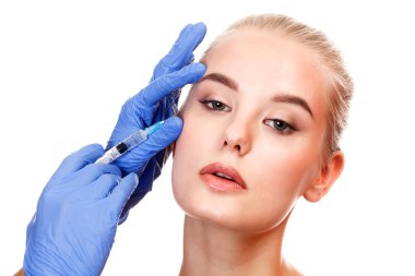 Bir hastanın yüzü içine güzellik enjeksiyon yapan doktor eller closeup çekim.