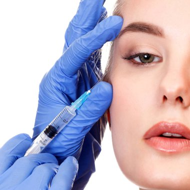 Bir hastanın yüzü içine güzellik enjeksiyon yapan doktor eller closeup çekim.