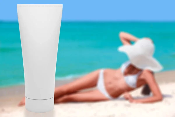 Tub med sun lotion med smal garvade kvinna på en strand bakom. Sommarlovet — Stockfoto