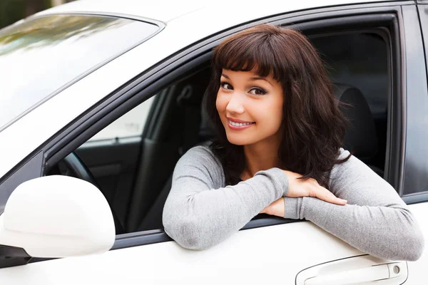 Feliz dueño de un coche nuevo. Joven mujer bonita conductor sonriendo a usted —  Fotos de Stock