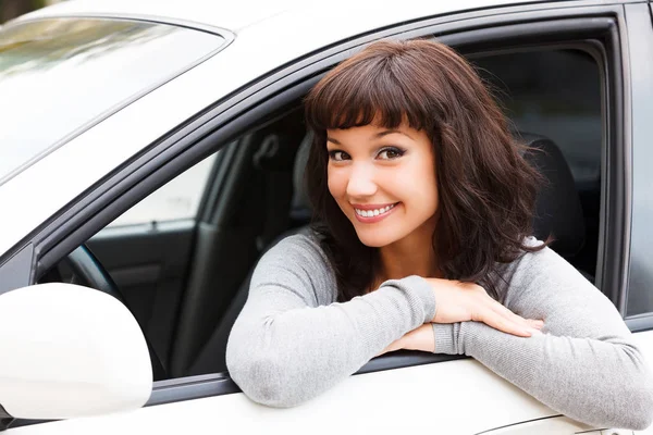 新しい車の幸せな所有者です。あなたに笑顔の若いきれいな女性ドライバー — ストック写真